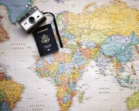 bunte Weltkarte mit altem Fotoapparat darauf und Reisepass