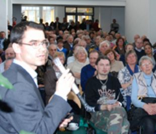 Vortragender Prof. Kartsen Müssig mit Mikrofon vor gefüllten Zuhörerreihen.