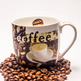 Kaffeetasse mit Kaffeebohnen drumherum